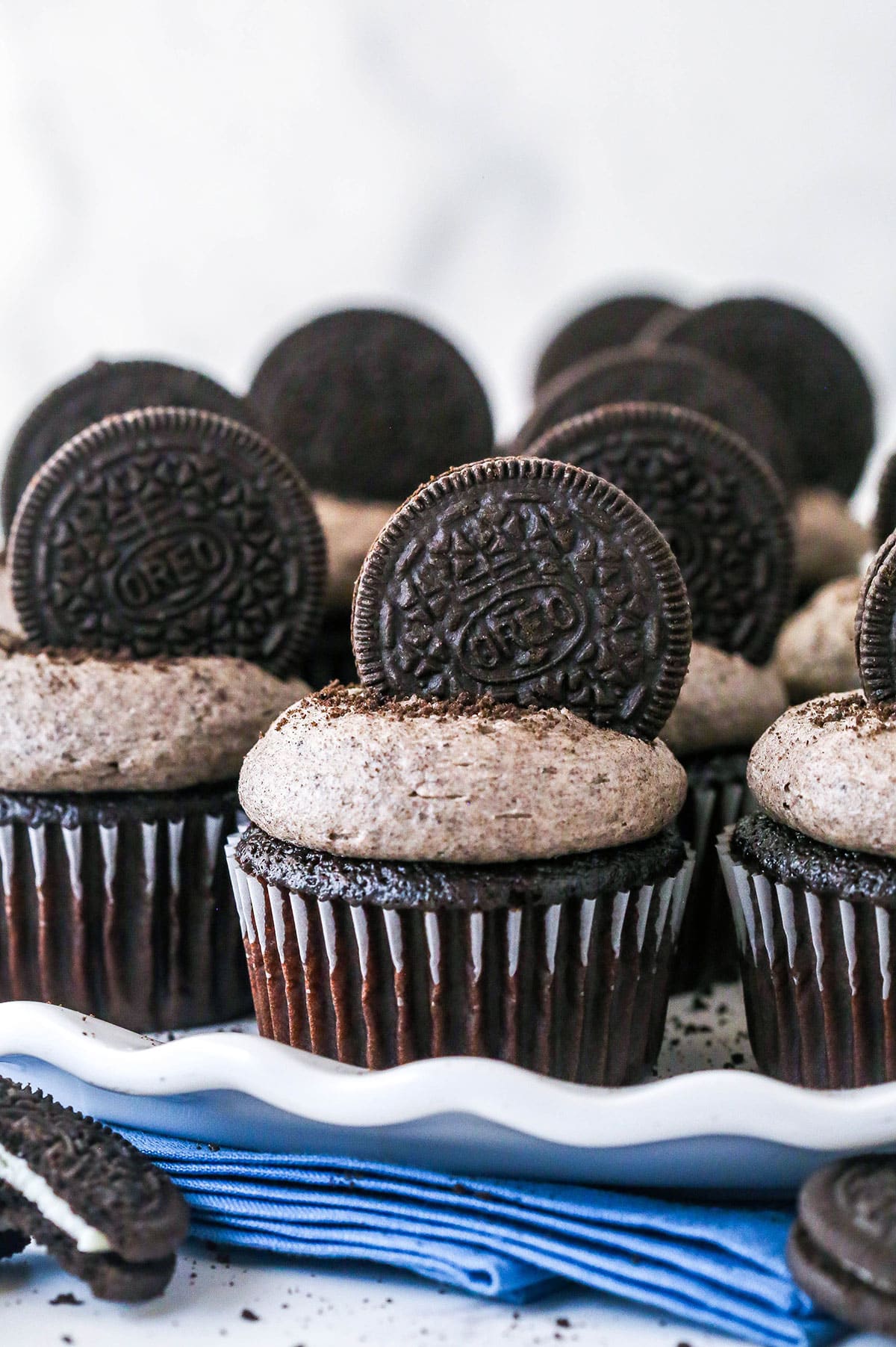 These Oreo Cupcakes are the answer to your Oreo craving! Creamy, Oreo-packed vanilla buttercream sits atop super moist chocolate cupcakes. Closeup of Oreo cupcakes on a serving platter.