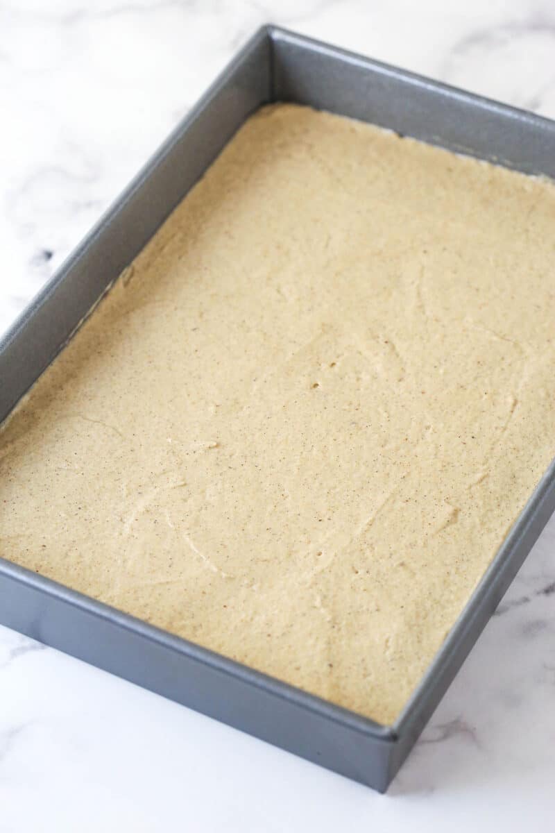 Batter for applesauce cake spread into a cake pan.