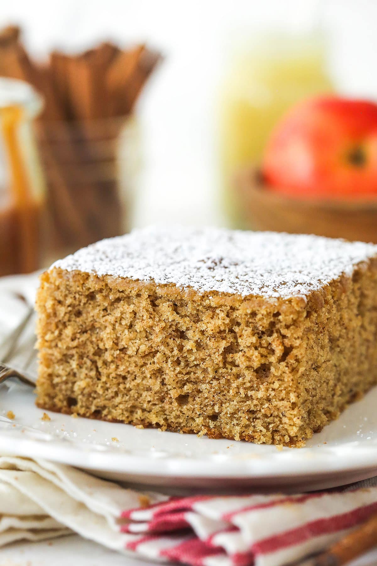 A slice of applesauce cake dusted with powdered sugar.