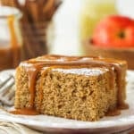 A slice of applesauce cake with caramel sauce drizzled over it.