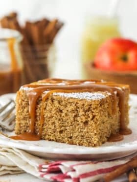 A slice of applesauce cake with caramel sauce drizzled over it.