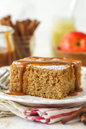 A slice of applesauce cake with caramel sauce drizzled over it.