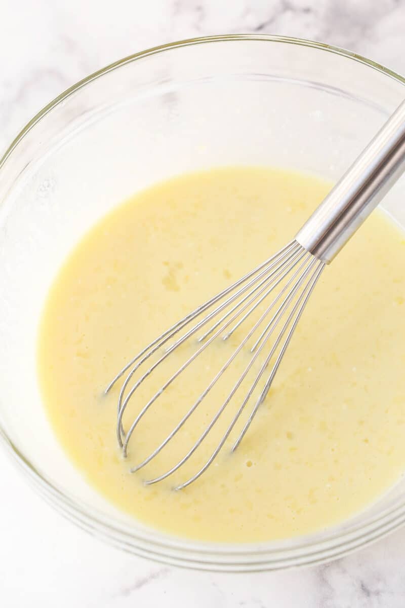Whisking together butter, sugar, egg, milk, sour cream, and vanilla.
