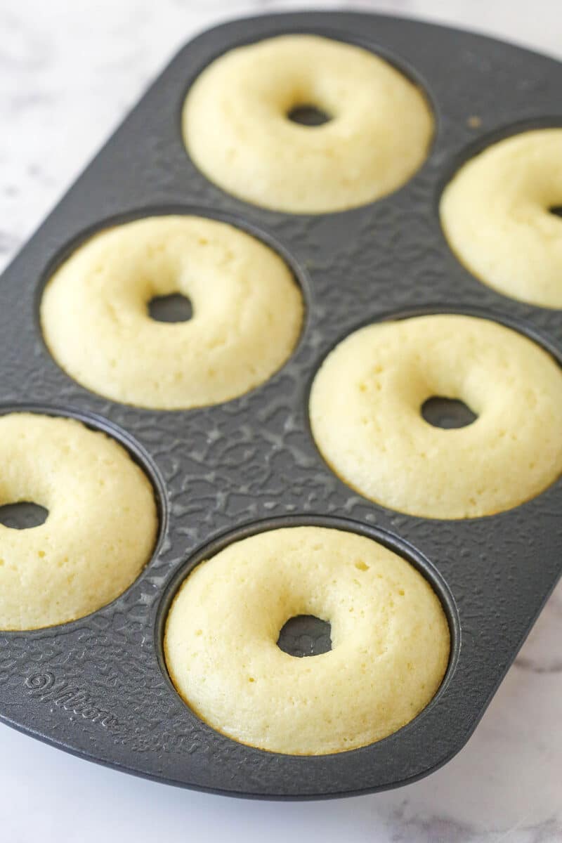 Baked donuts cooling in the baking pan.
