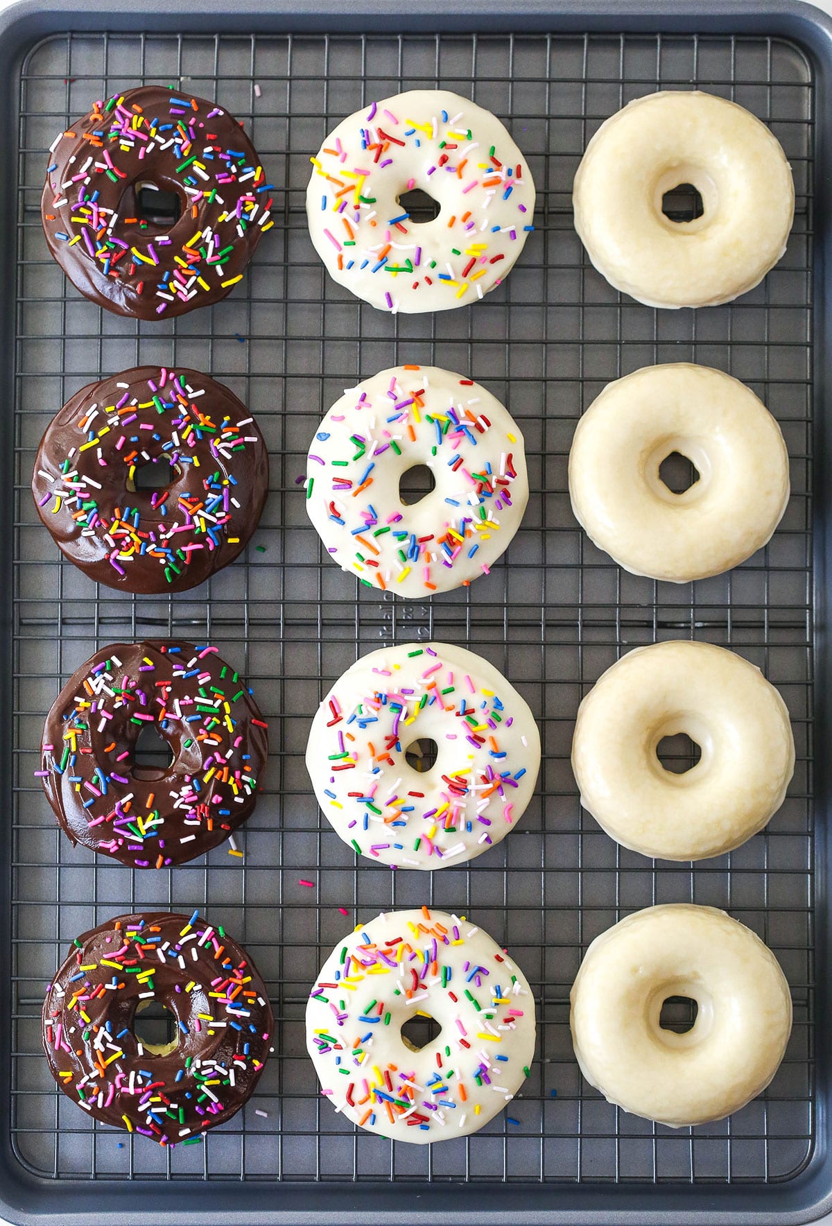 Icing setting on baked donuts on a cooling rack.