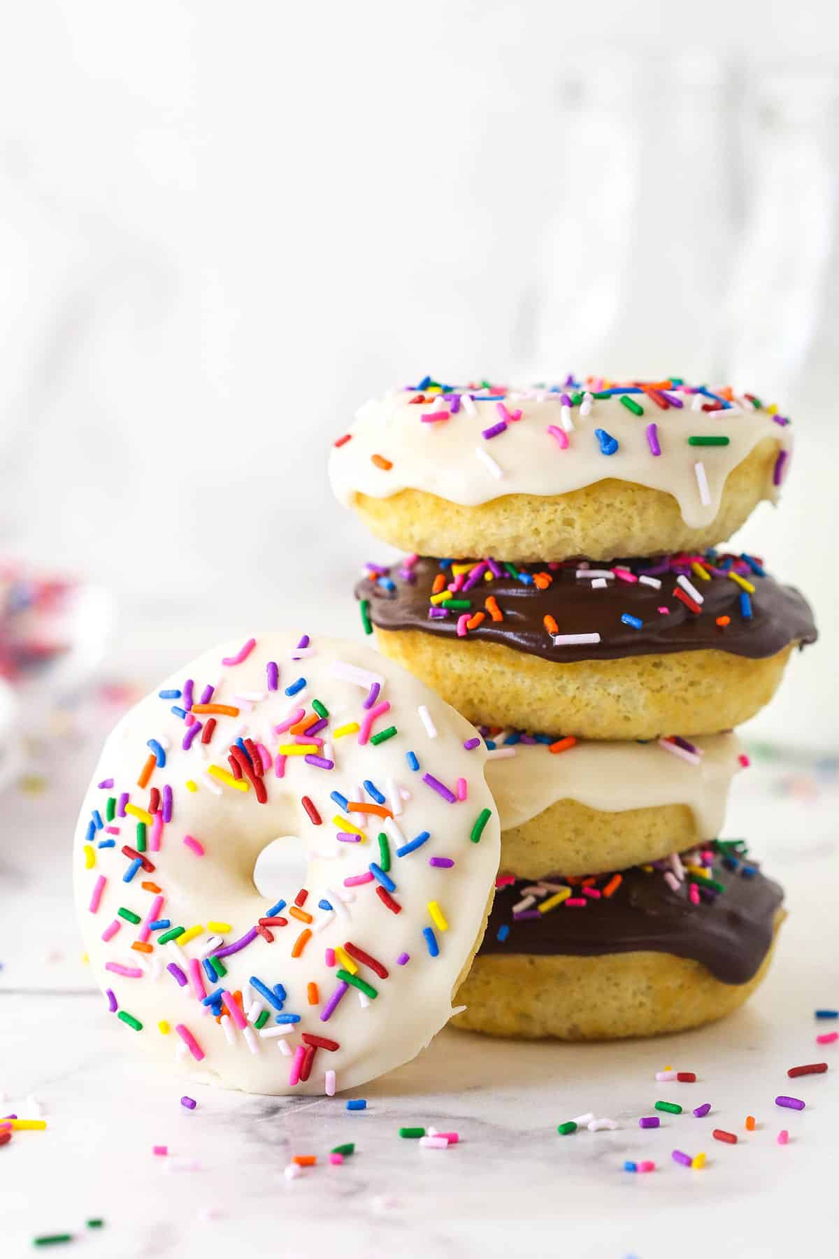 A stack of baked donuts with one donuts leaning against it.