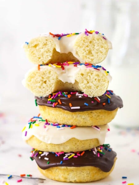 A stack of baked donuts. The top one is cut in half.