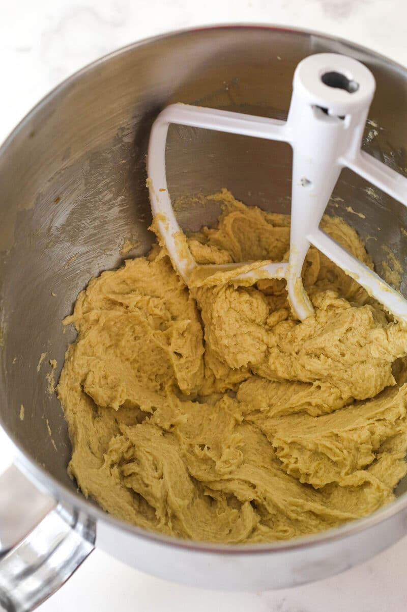 Mixing the egg and vanilla into creamed butter and sugar.