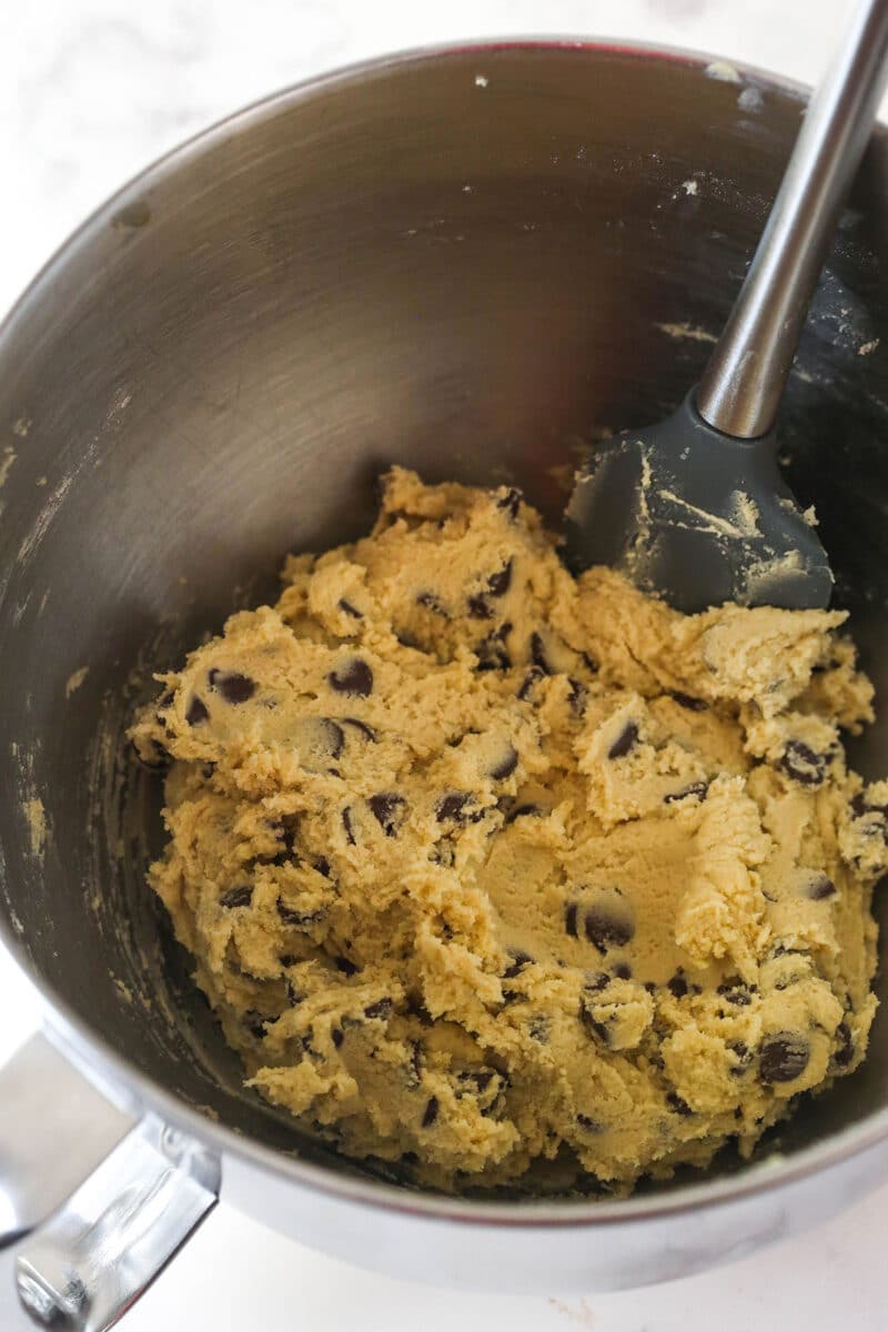 Folding chocolate chips into cookie dough layer for brookies.