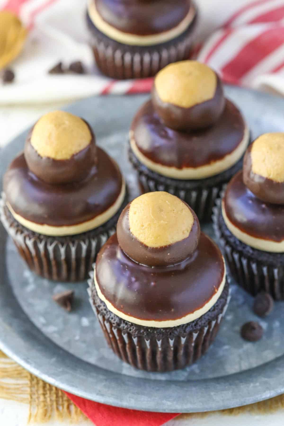 Top view of four peanut butter chocolate buckeye cupcakes on a metal tray.