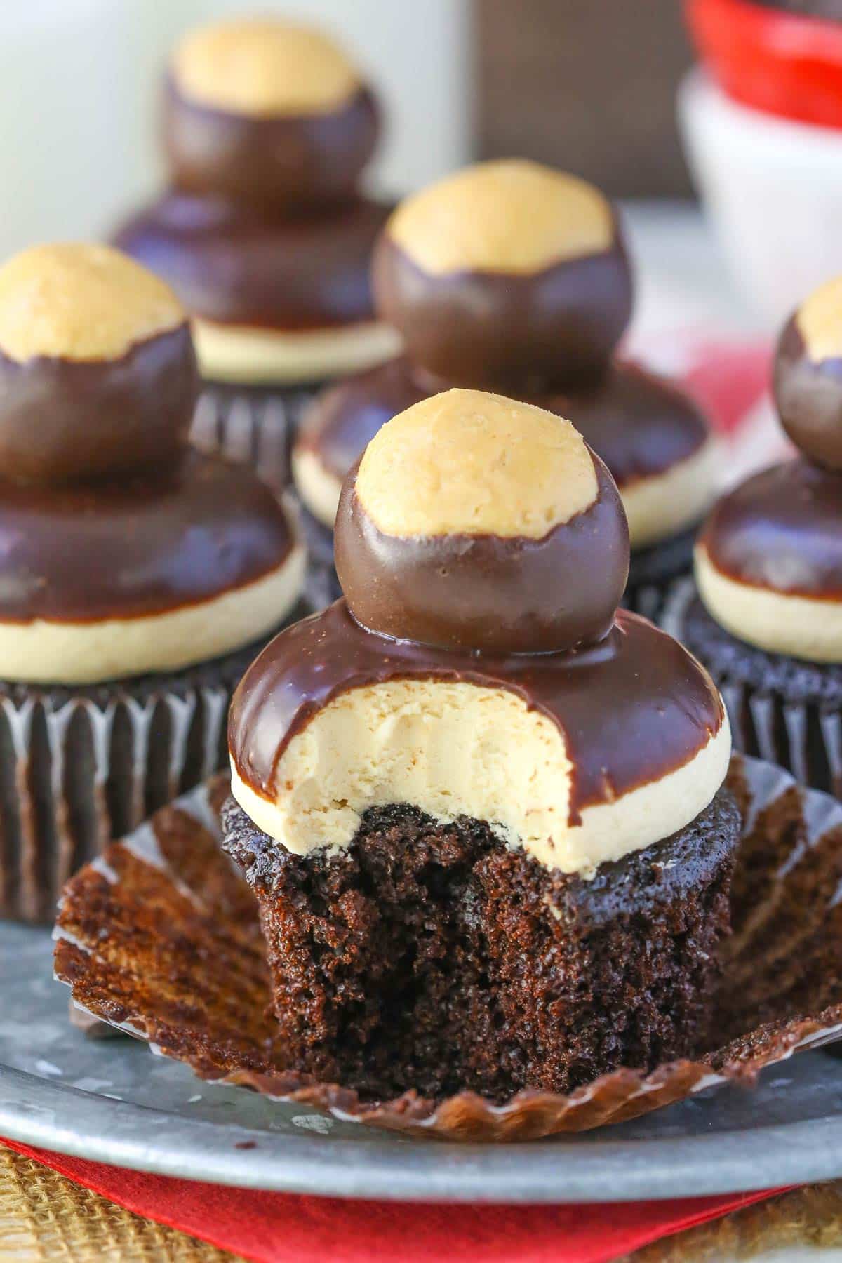 Close up of a peanut butter chocolate buckeye cupcake with a bite taken out of it.