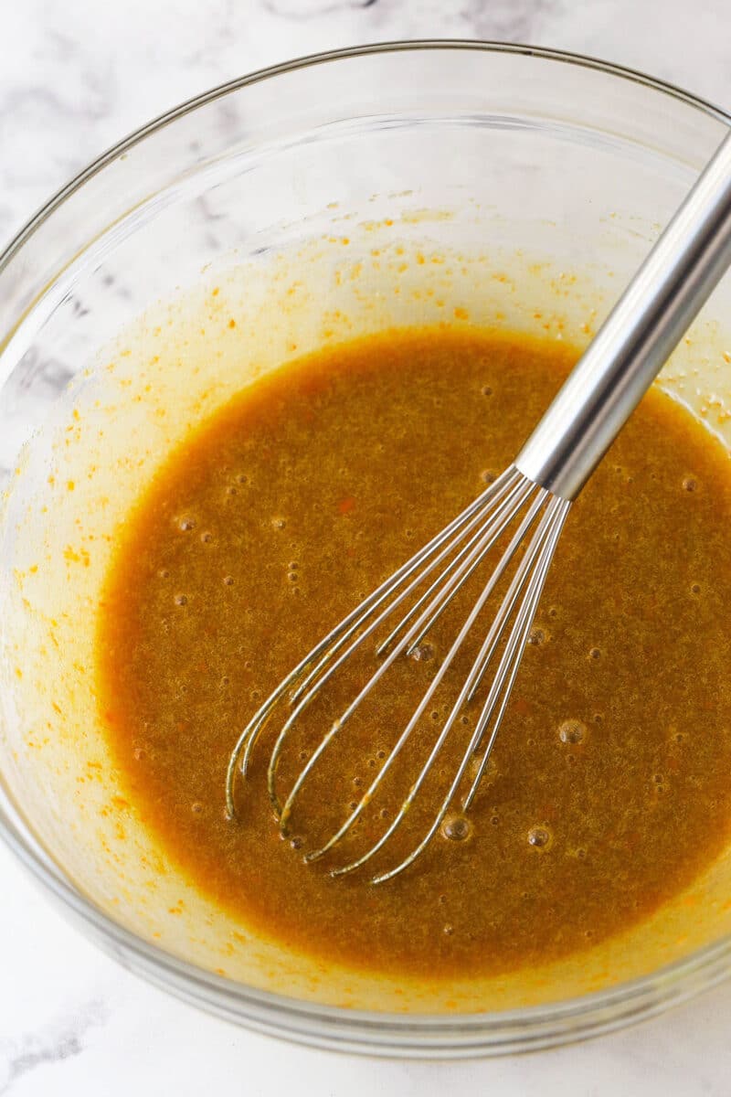 Whisking together butter, sugar, eggs, vanilla extract, and carrot puree.