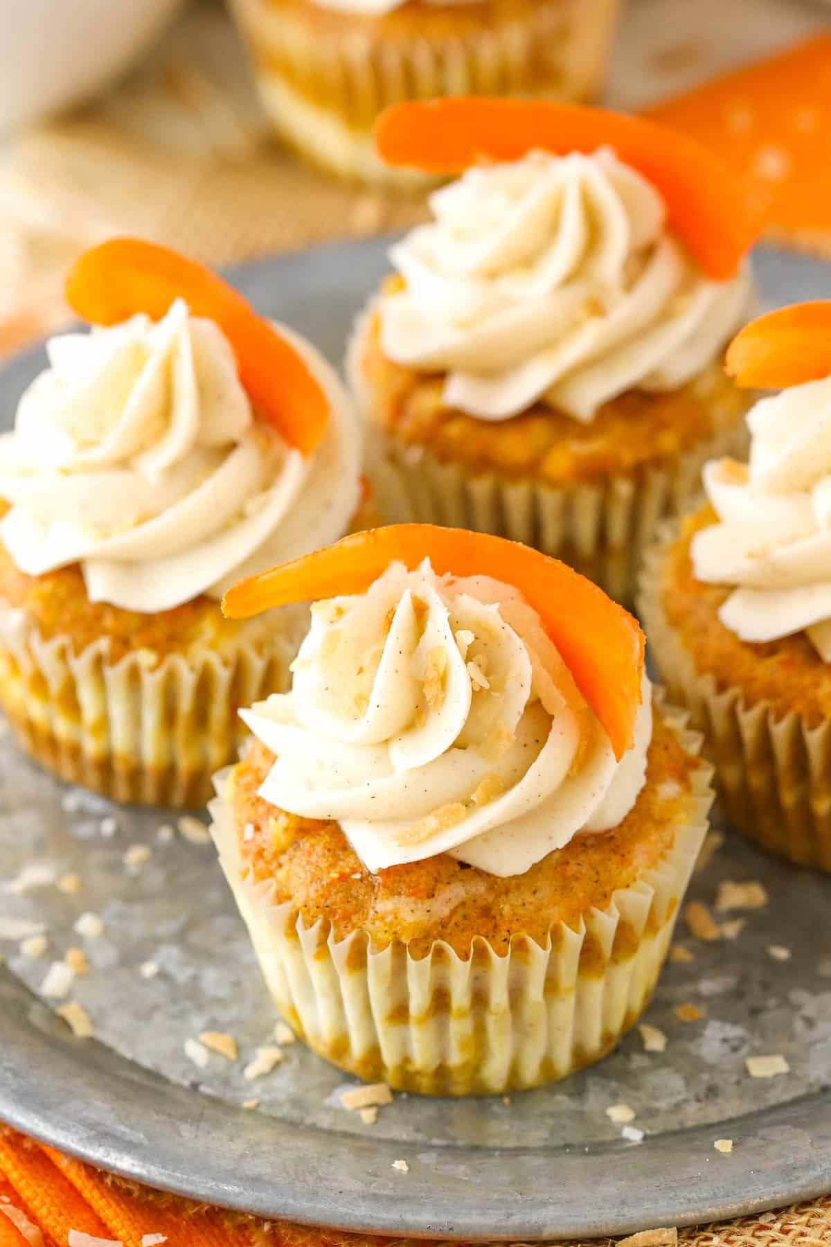 Four carrot cake cheesecake swirl cupcakes on a metal tray.