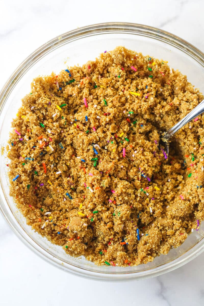 Mixing together the ingredients for a funfetti graham cracker crust.
