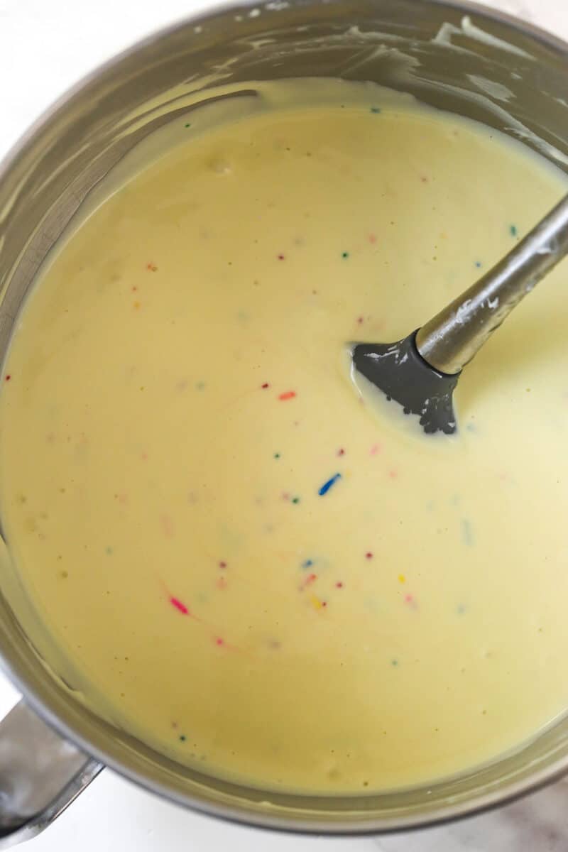 Mixing the eggs and sprinkles into Funfetti cheesecake batter.