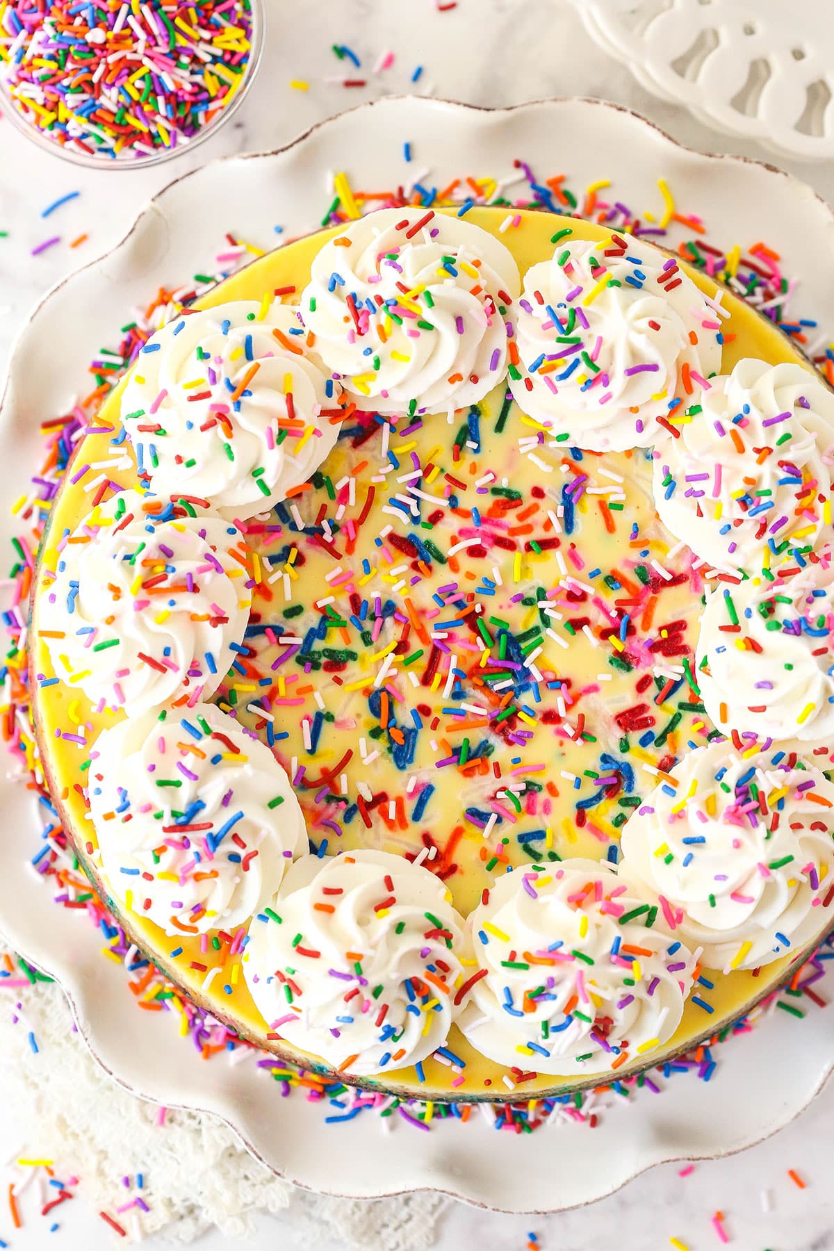 Overhead view of funfetti cheesecake on a cake platter.
