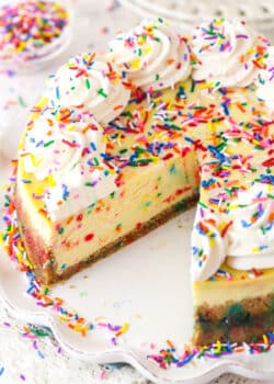 Funfetti cheesecake with a couple of slices taken out of it.