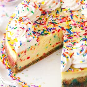 Funfetti cheesecake with a couple of slices taken out of it.