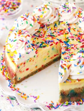 Funfetti cheesecake with a couple of slices taken out of it.