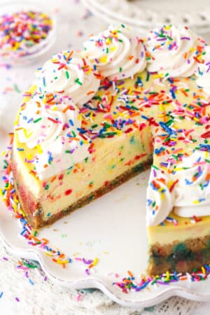 Funfetti cheesecake with a couple of slices taken out of it.