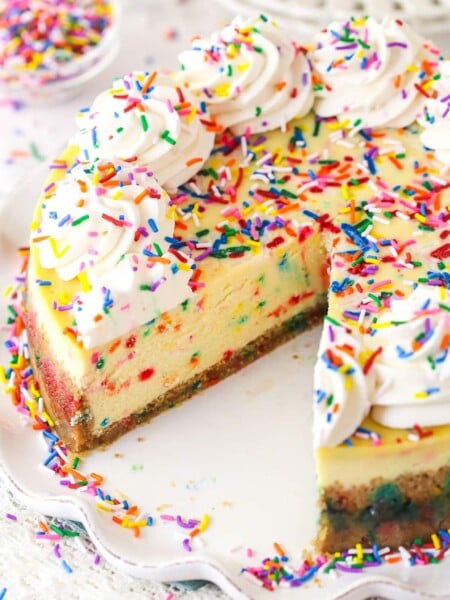 Funfetti cheesecake with a couple of slices taken out of it.