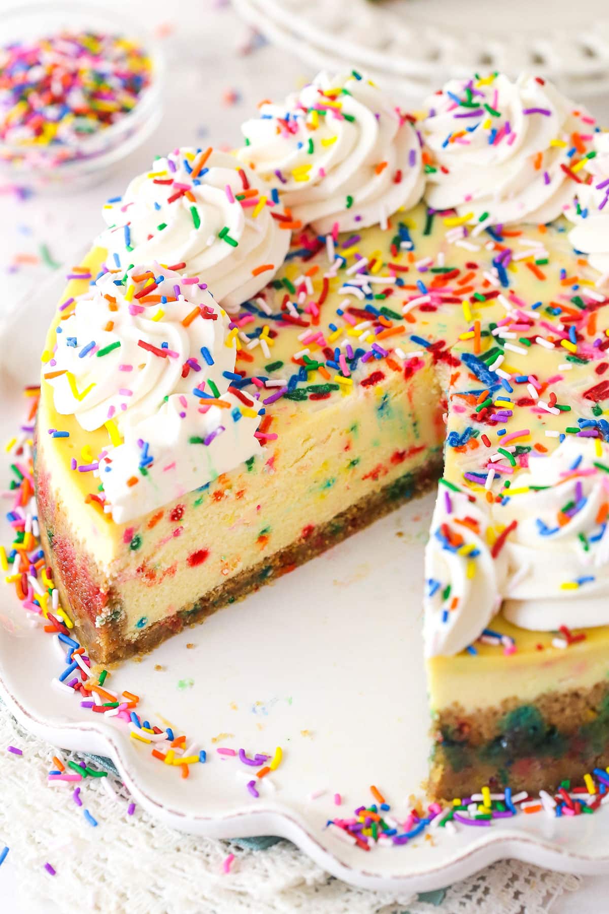 Funfetti cheesecake with a couple of slices taken out of it.
