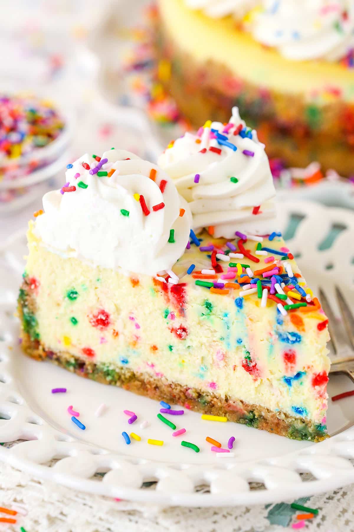 A slice of Funfetti cheesecake on a plate.