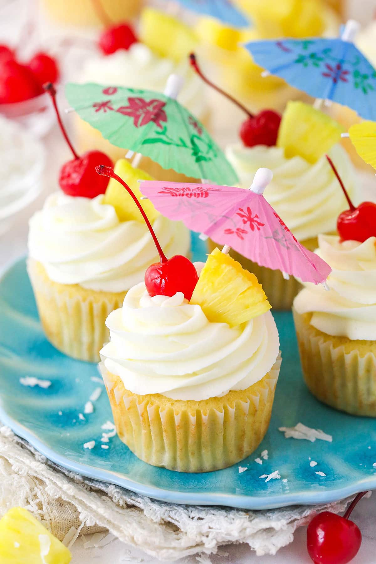 Four pina colada cupcakes on a plate.