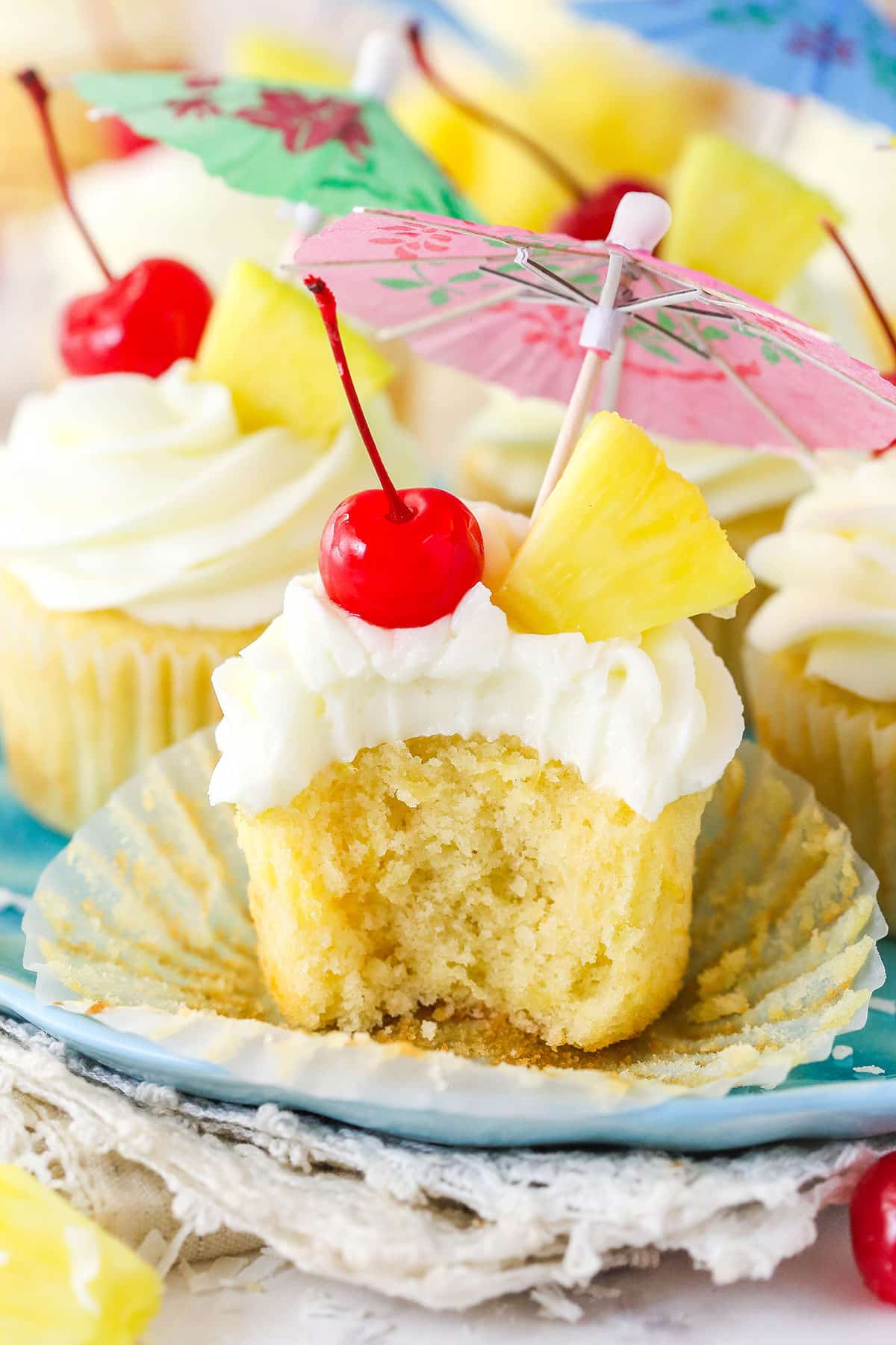 A pina colada cupcake with a bite taken out of it.