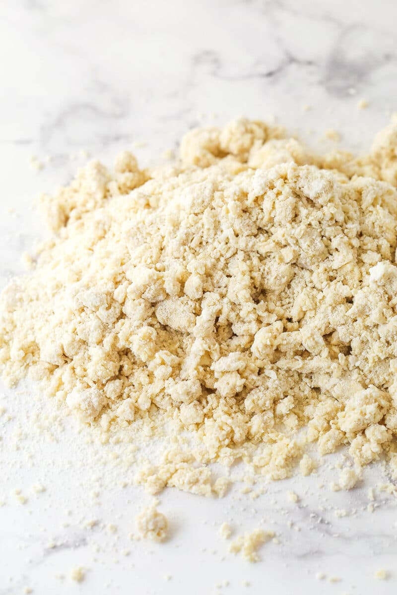 Scone dough turned out onto a work surface, waiting to be pulled together into a ball.