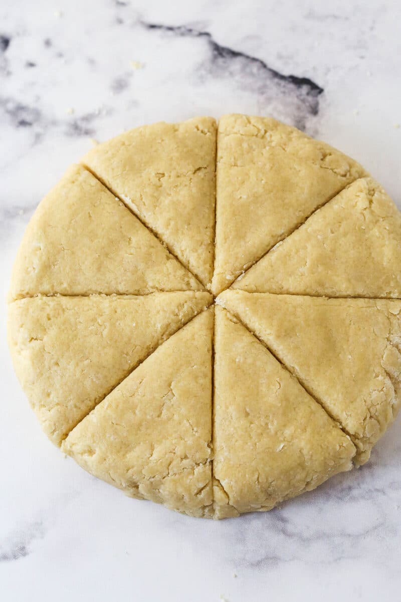A disk of scone dough cut into wedges.