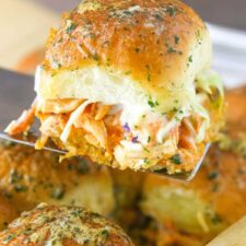 A spatula holding up a buffalo chicken slider.