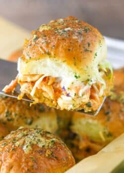 A spatula holding up a buffalo chicken slider.
