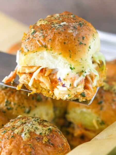 A spatula holding up a buffalo chicken slider.