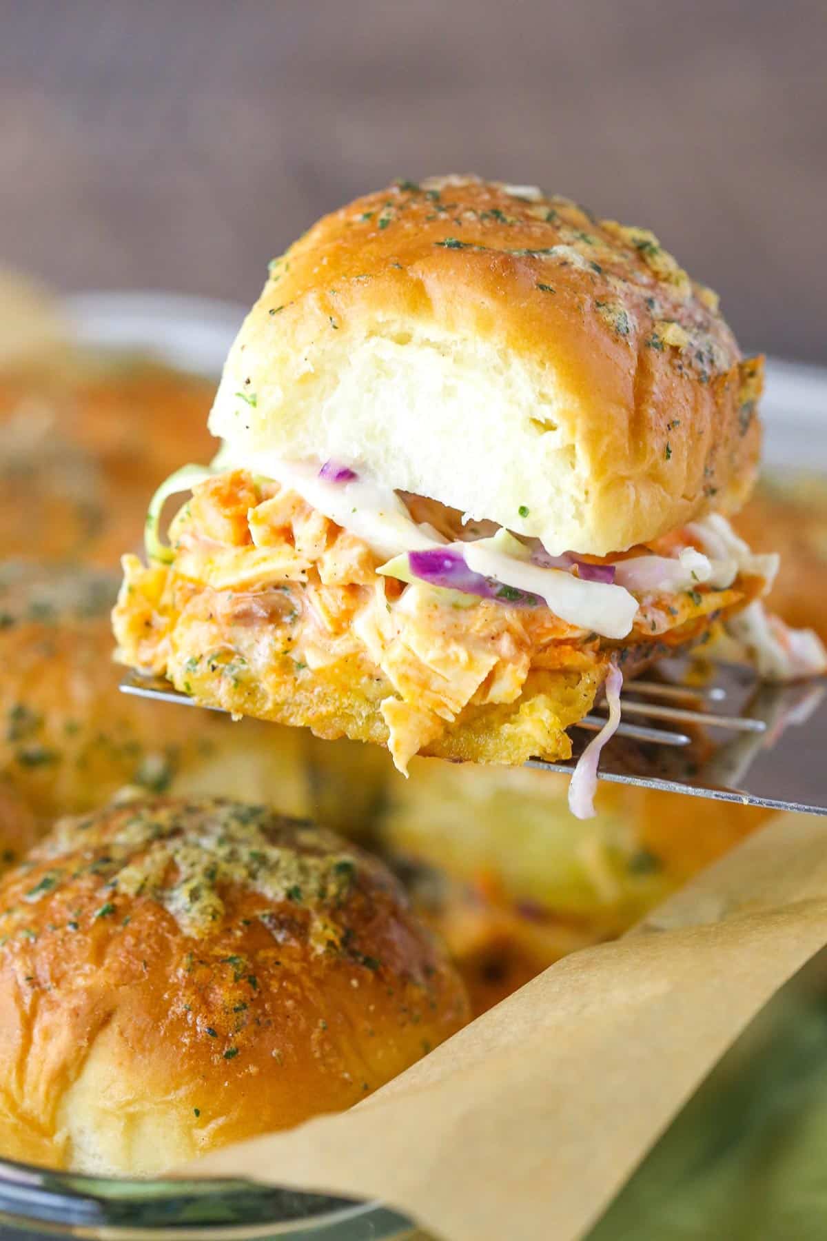 Close up of a buffalo chicken slider on a spatula.
