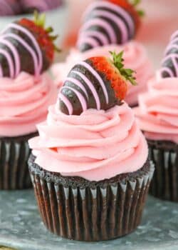 Close up of a chocolate covered strawberry cupcake on a silver tray.