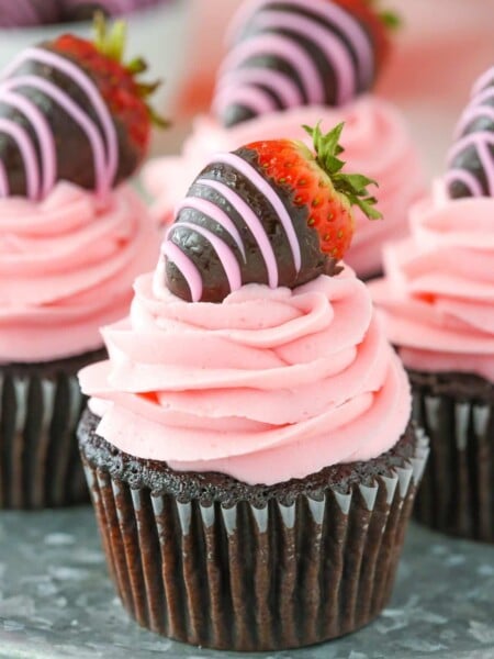 Close up of a chocolate covered strawberry cupcake on a silver tray.