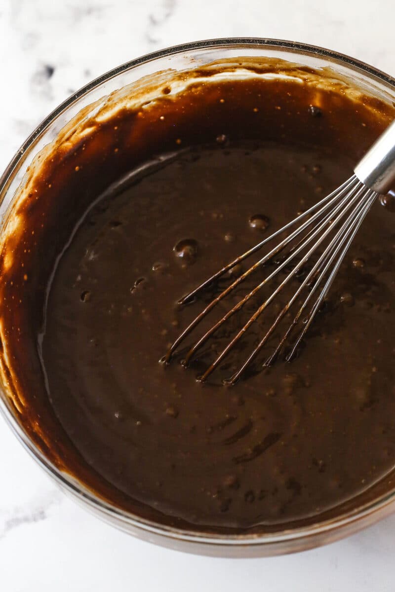 These Chocolate Muffins are so tender and supremely moist. Plus, they're loaded with chocolate flavor and packed with chocolate chips! Whisking the wet ingredients for chocolate muffins into the batter.