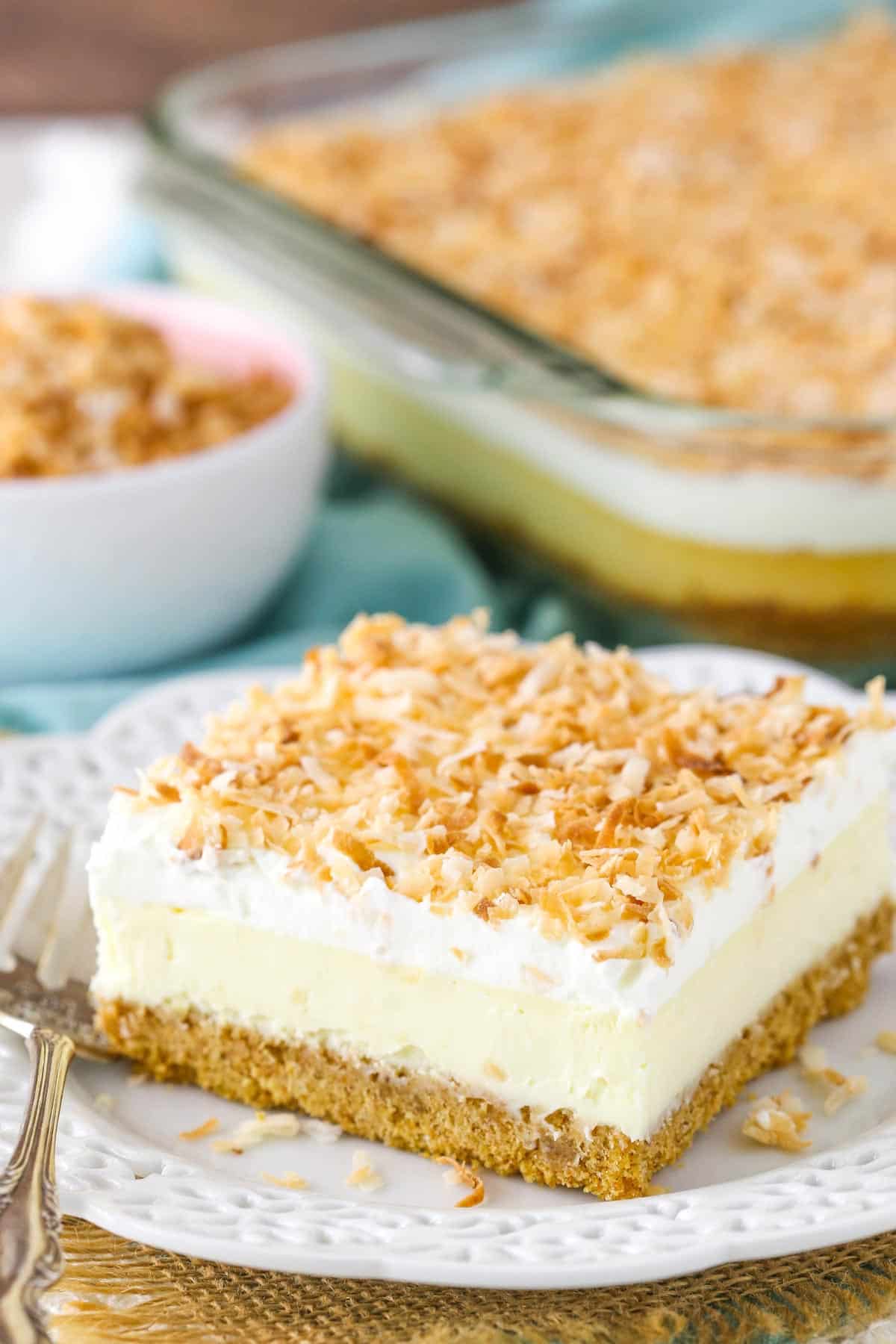Close up of a slice of easy coconut cheesecake on a small white plate.