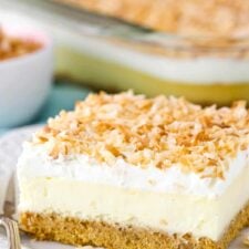 Close up of a slice of easy coconut cheesecake on a small white plate.