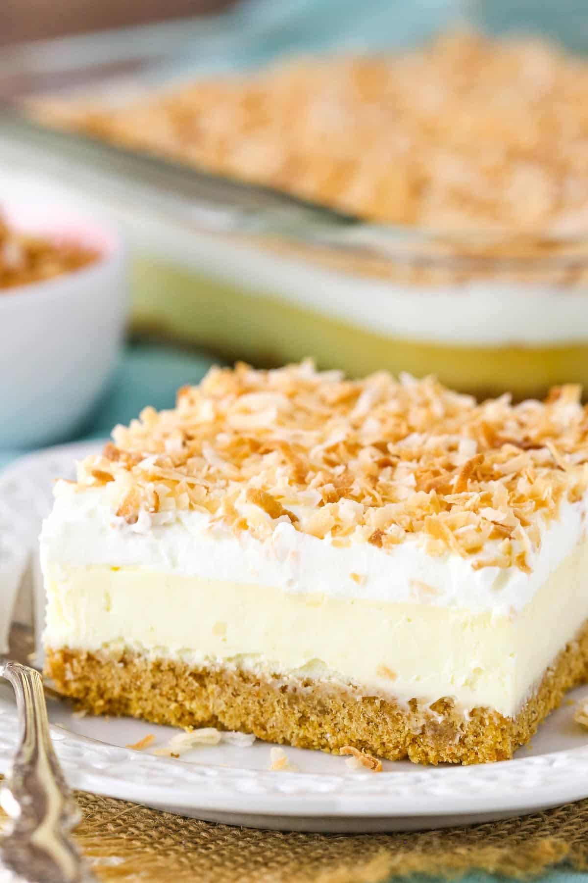 Close up of a slice of easy coconut cheesecake on a small white plate.