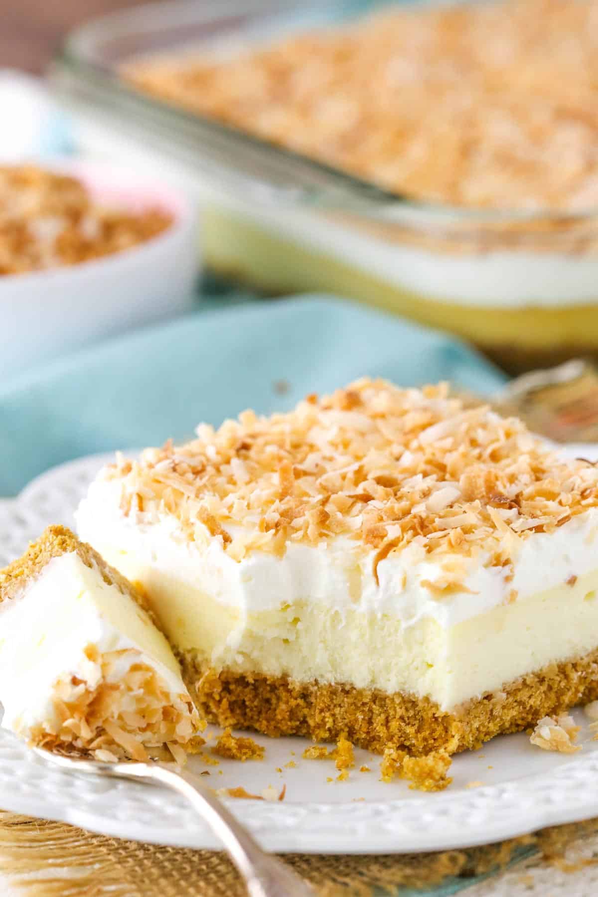 A slice of easy coconut cheesecake with a bite removed.