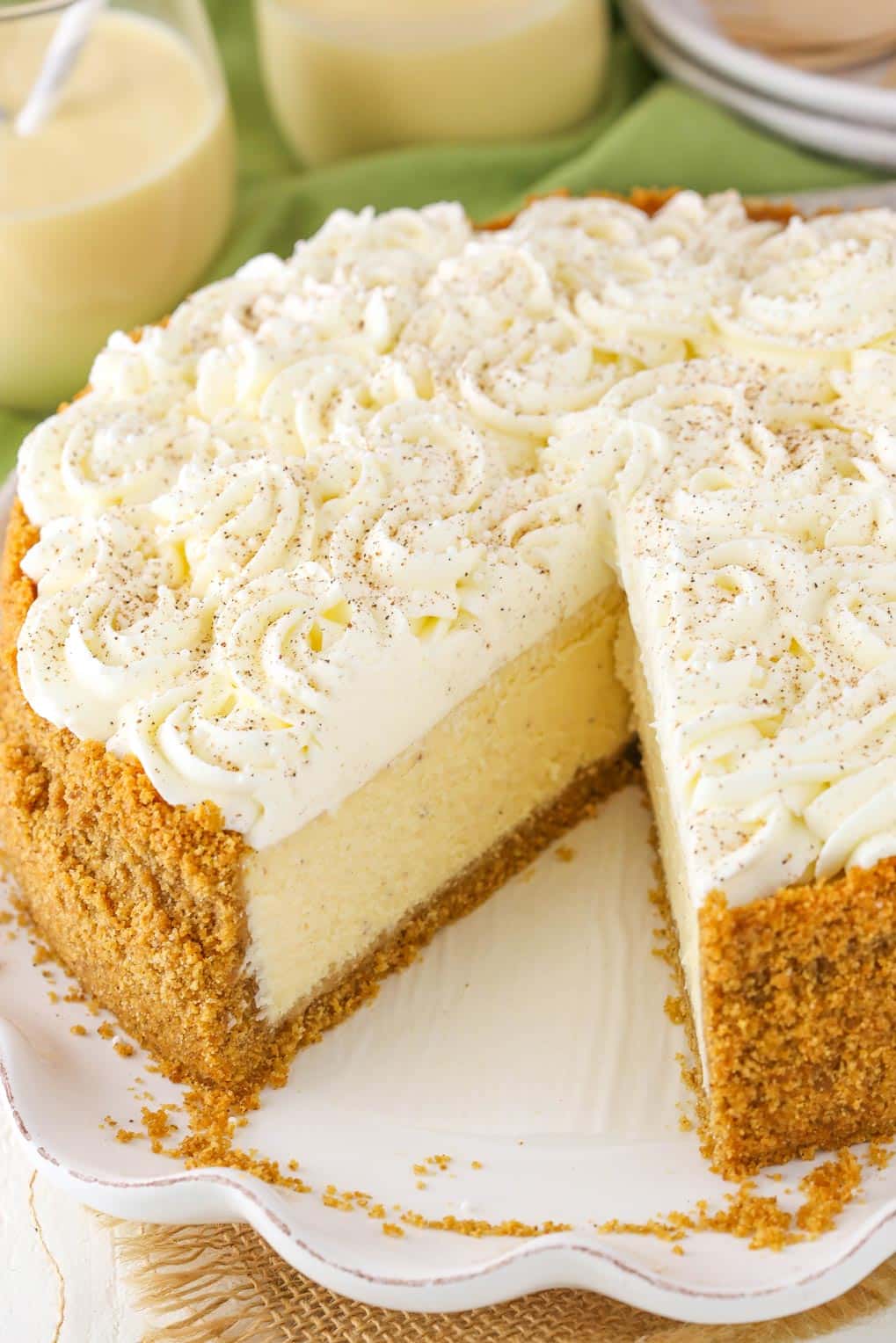 An eggnog cheesecake with a slice removed to show interior.