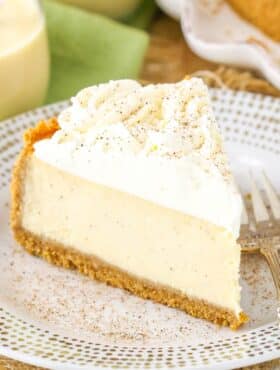 A slice of eggnog cheesecake on a small white plate.