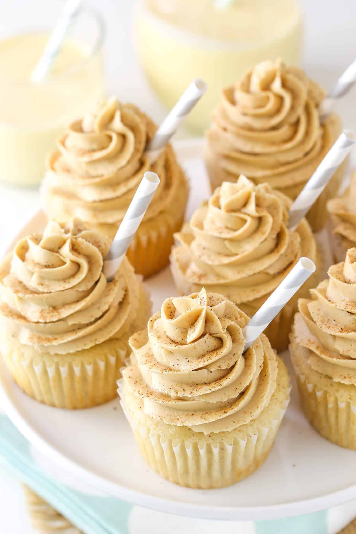 Top view of eggnog latte cupcakes on a white cake plate.