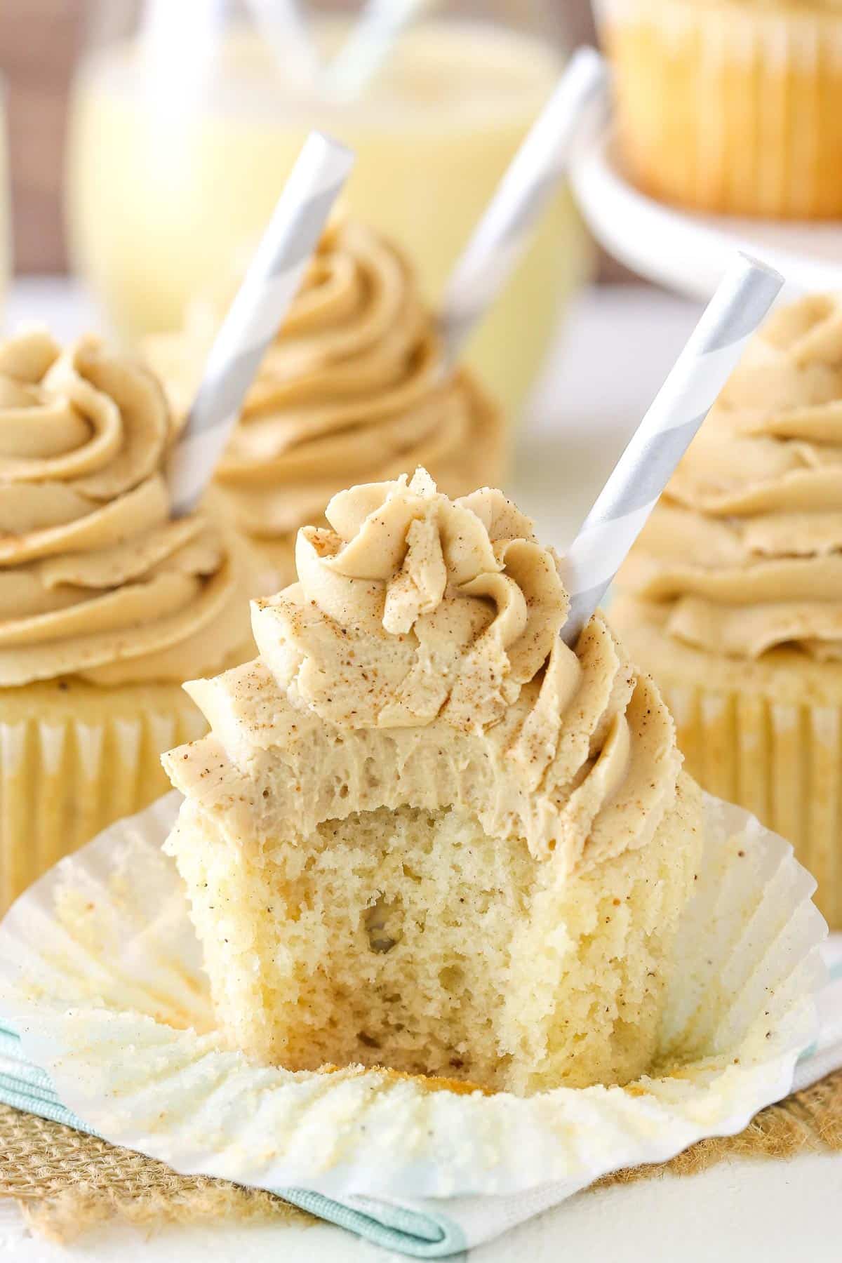 An eggnog latte cupcake with a bite removed.