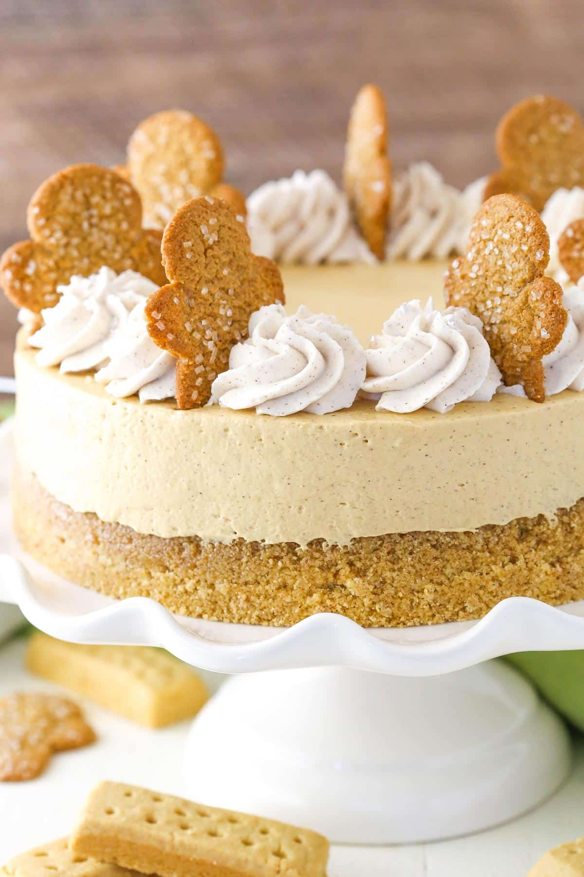 A gingerbread cheesecake on a white ruffled cake plate.
