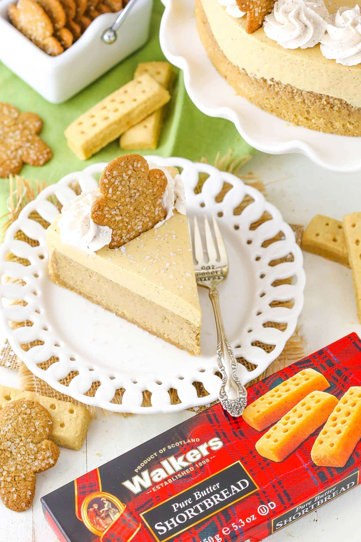 A slice of gingerbread cheesecake next to a box of shortbread.