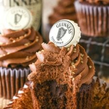 A Guinness chocolate cupcake with a bite out of it.