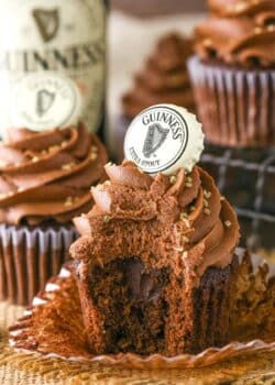 A Guinness chocolate cupcake with a bite out of it.